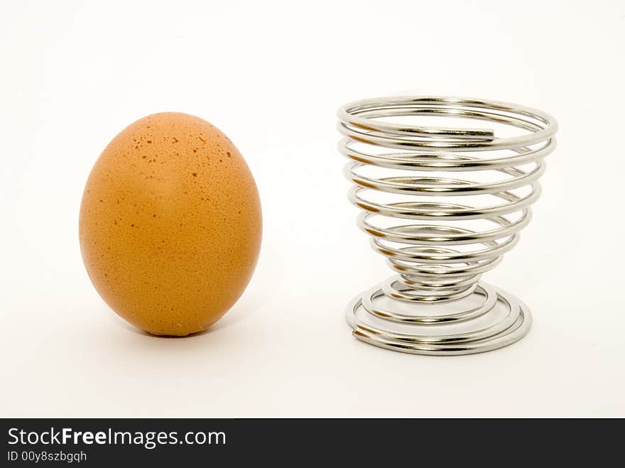 Still-life with an egg and an egg cup placed over white background. Still-life with an egg and an egg cup placed over white background