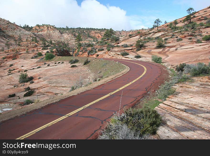 Red road leading to the mountains of the Zion National Park. Utah. USA. Red road leading to the mountains of the Zion National Park. Utah. USA