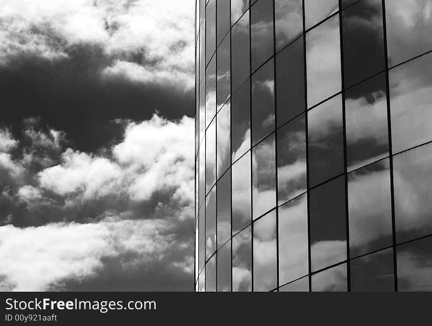 The glass windows of a skyscraper and clouds' reflections in Belize City, Belize. The glass windows of a skyscraper and clouds' reflections in Belize City, Belize.