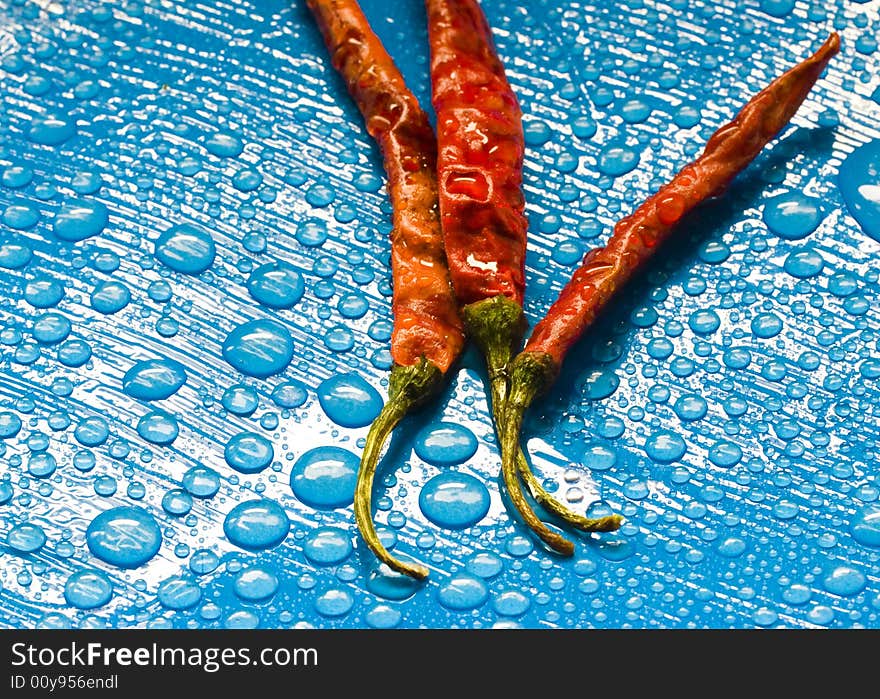 Dried red chili peppers and water drops. Dried red chili peppers and water drops.