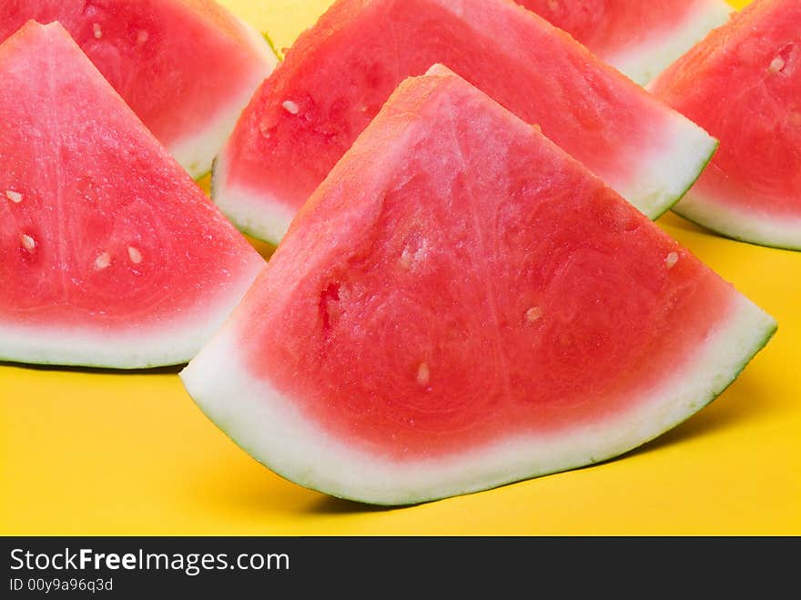 Juicy slices of watermelon in yellow background