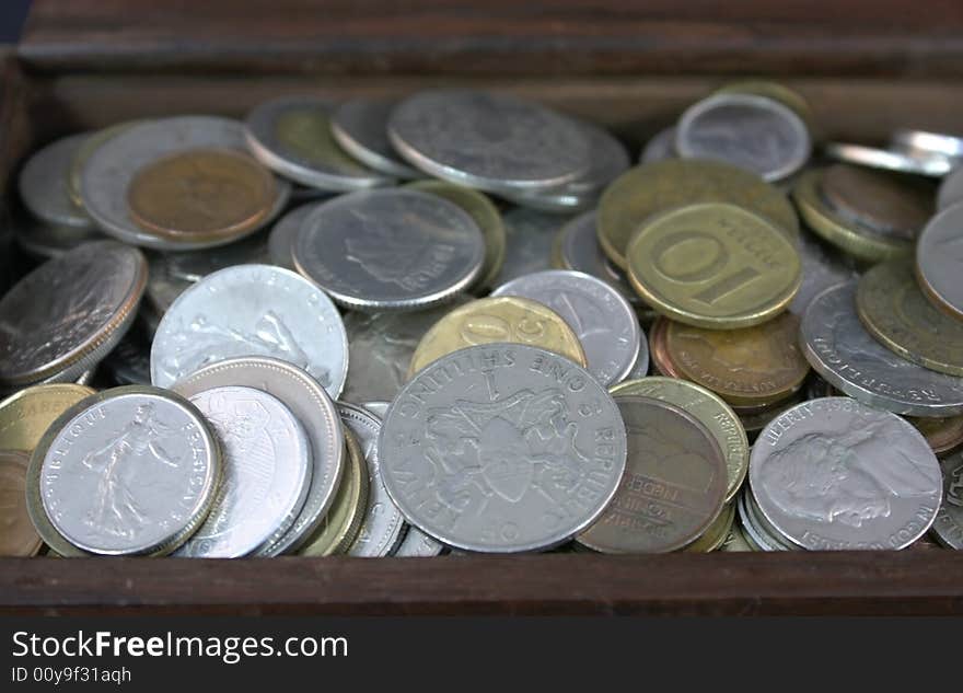 Coins in international currencies collected in a box. Coins in international currencies collected in a box