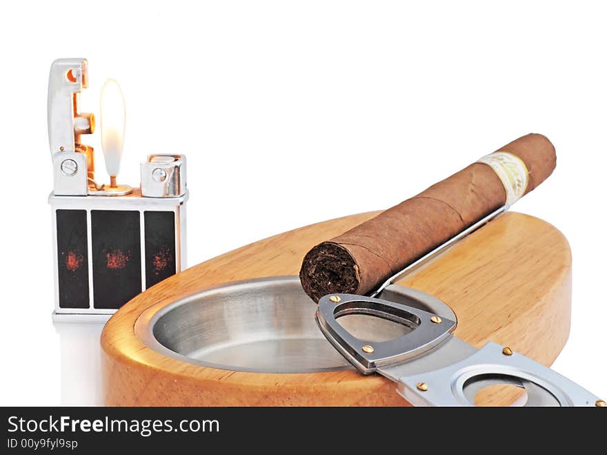 Close up of stylish elegant wood and metallic ashtray, lighter and cuban cigar