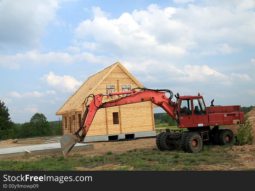 New house with digger in a front. New house with digger in a front