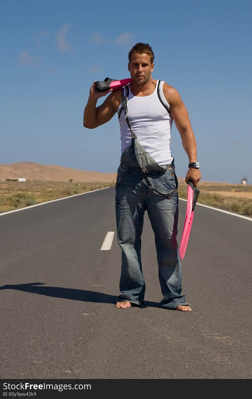 Young athetlic man in the middle of a road. Young athetlic man in the middle of a road