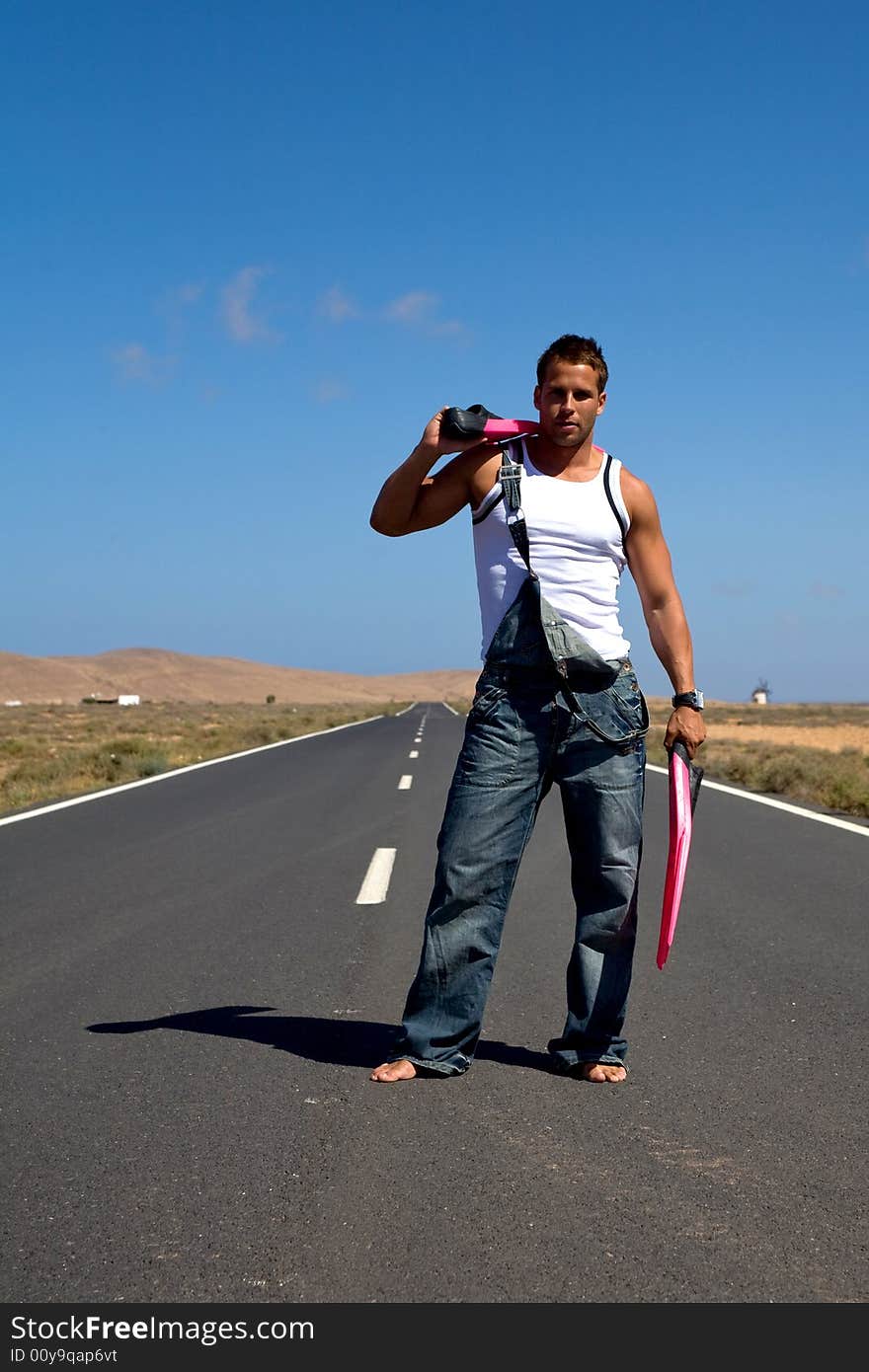 Young athetlic man in the middle of a road. Young athetlic man in the middle of a road