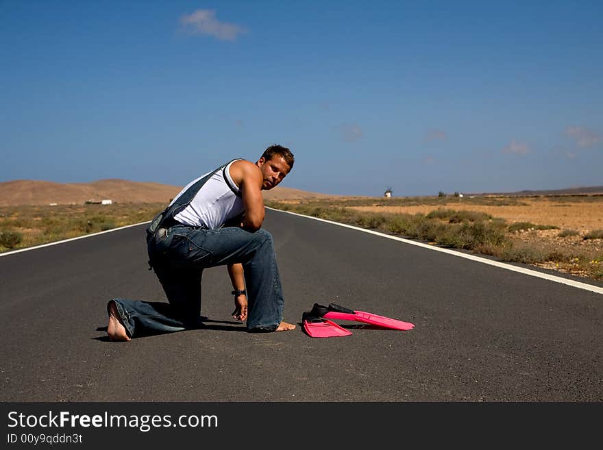 Young athetlic man in the middle of a road. Young athetlic man in the middle of a road