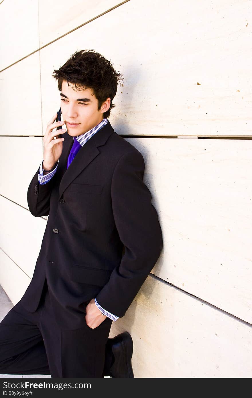 Businessman at phone over white wall