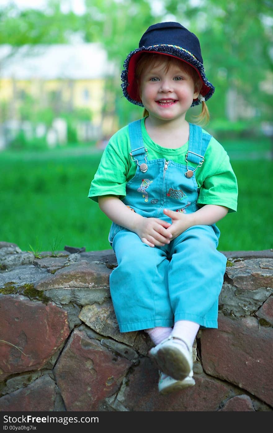 Beauty baby sit on stone wall