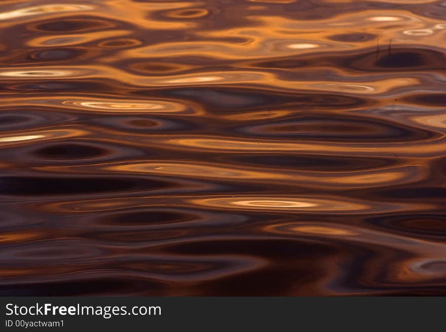 Colorful reflections on a water surface. Reflection of the sky at a sunset.