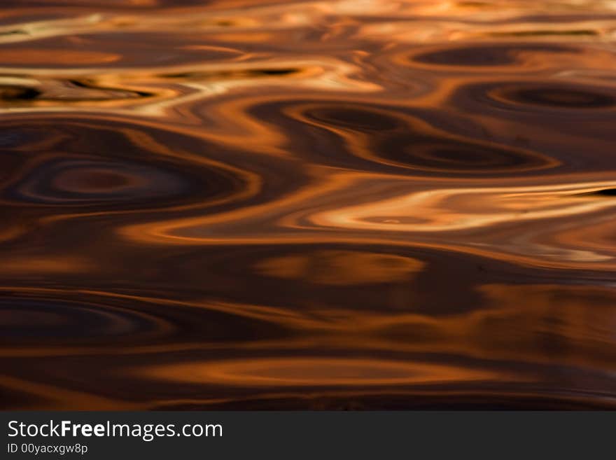 Colorful reflections on a water surface. Reflection of the sky at a sunset.