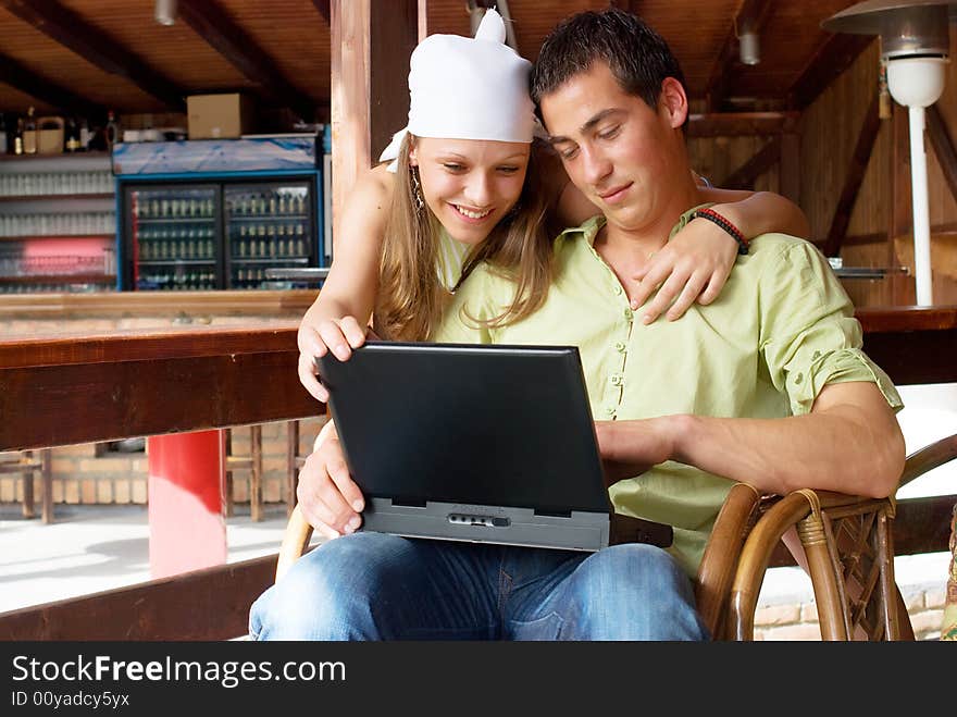 Young man and woman in restaurant with laptop. Young man and woman in restaurant with laptop