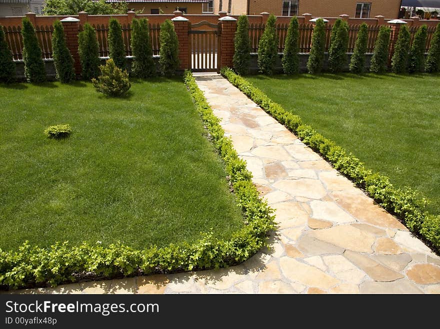 Garden stone path with grass growing up between the stones