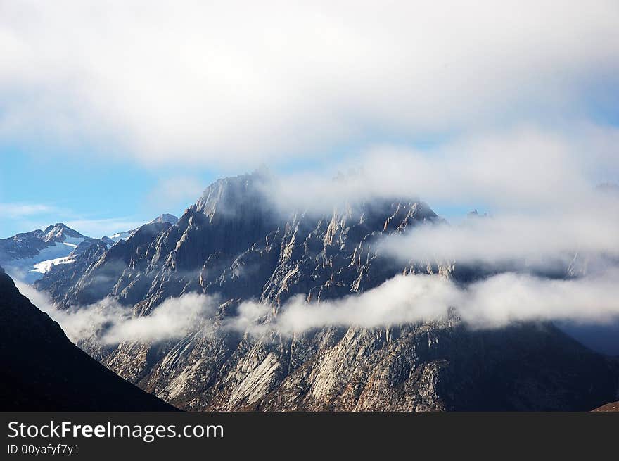 When travelling in Tibet of China, a grand mountain in clouds appears in front of us. When travelling in Tibet of China, a grand mountain in clouds appears in front of us.