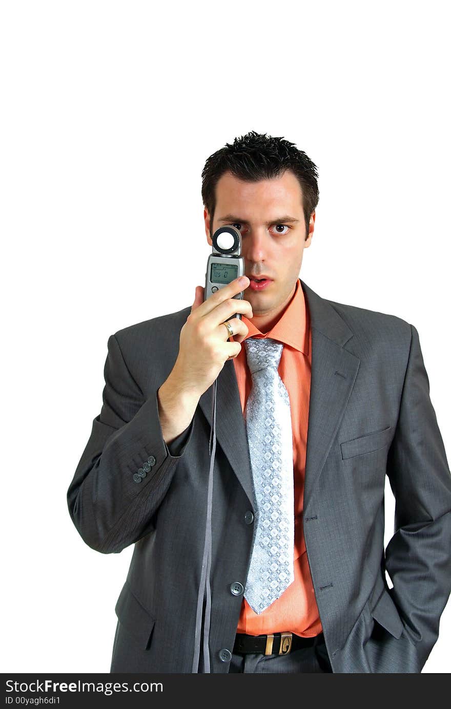 A man, wearing suit, holding a light meter in his hand, looking at the camera. A man, wearing suit, holding a light meter in his hand, looking at the camera