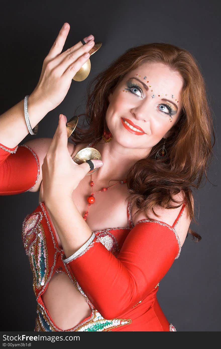 Belly Dancer wearing a red costume with jewelery. Belly Dancer wearing a red costume with jewelery