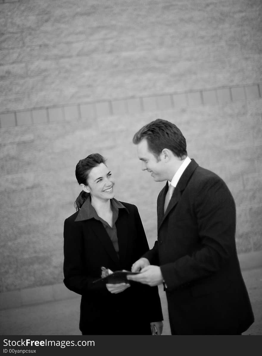 Businessman and businesswoman standing working together discussing. Businessman and businesswoman standing working together discussing