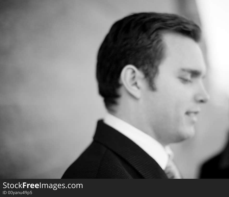 Close up of single white businessman in suit and tie standing looking down