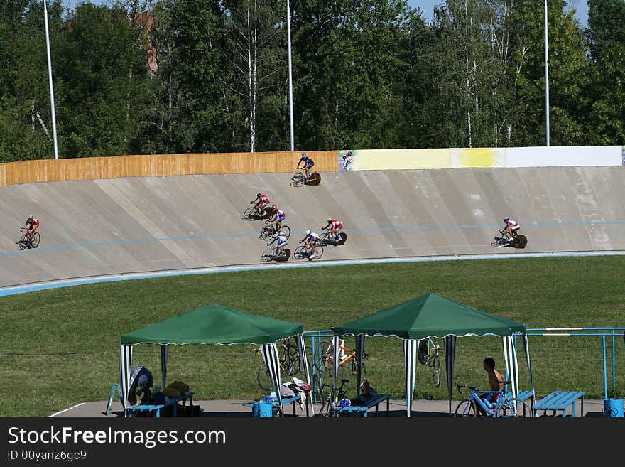 Team of bicyclists on a bicycle track during competitions. Team of bicyclists on a bicycle track during competitions