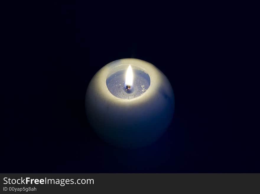 Burning candle on a black background