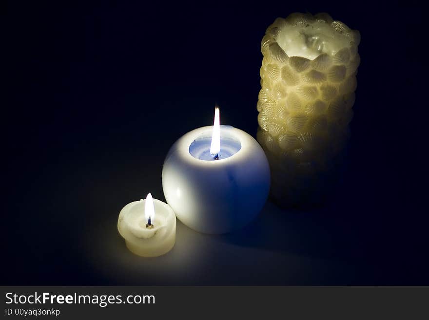 Three burning candles on a black background. Three burning candles on a black background