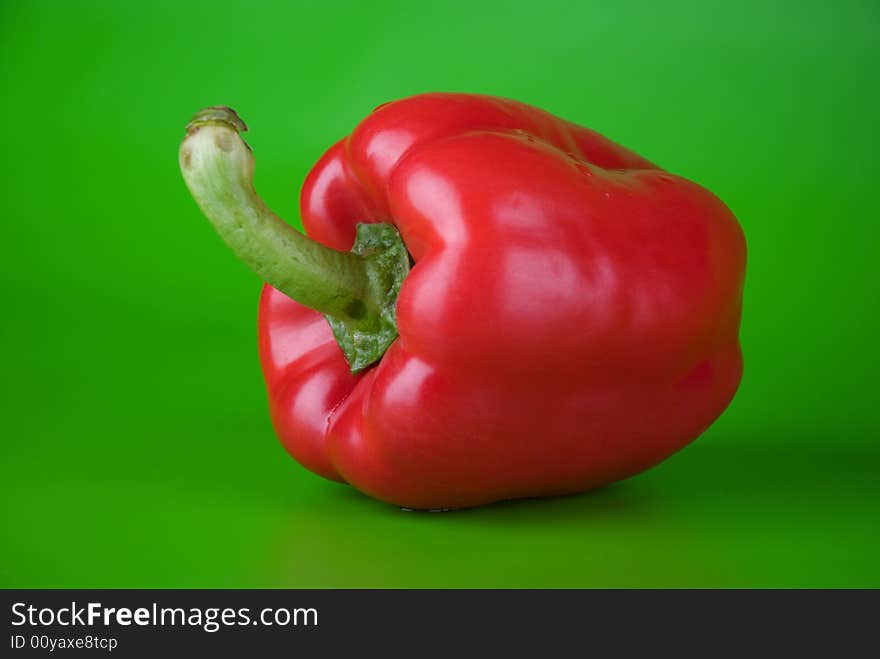 Red paprika on the green bright background