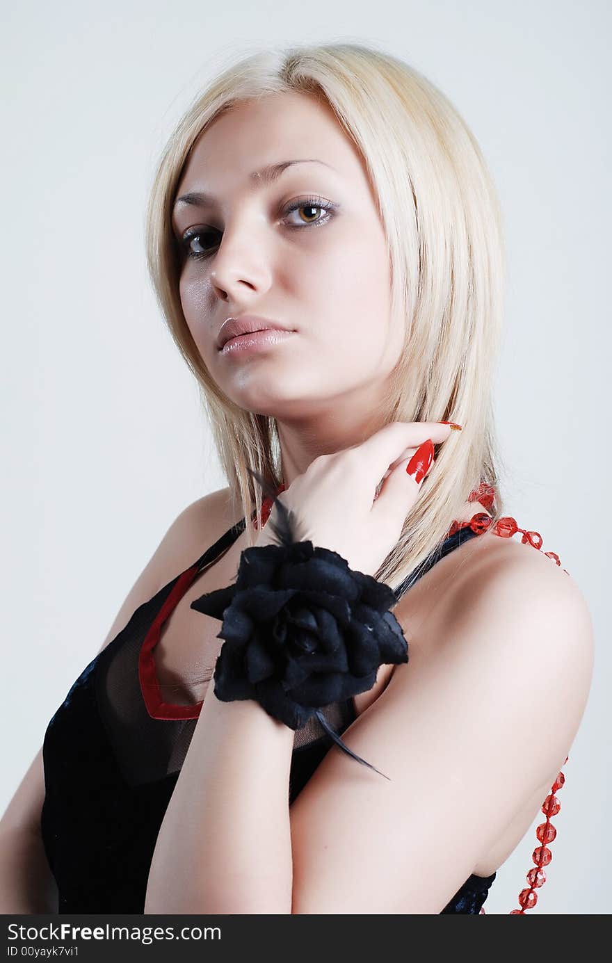 The beautiful blonde with red roses on a neck and a black rose on hand. The beautiful blonde with red roses on a neck and a black rose on hand