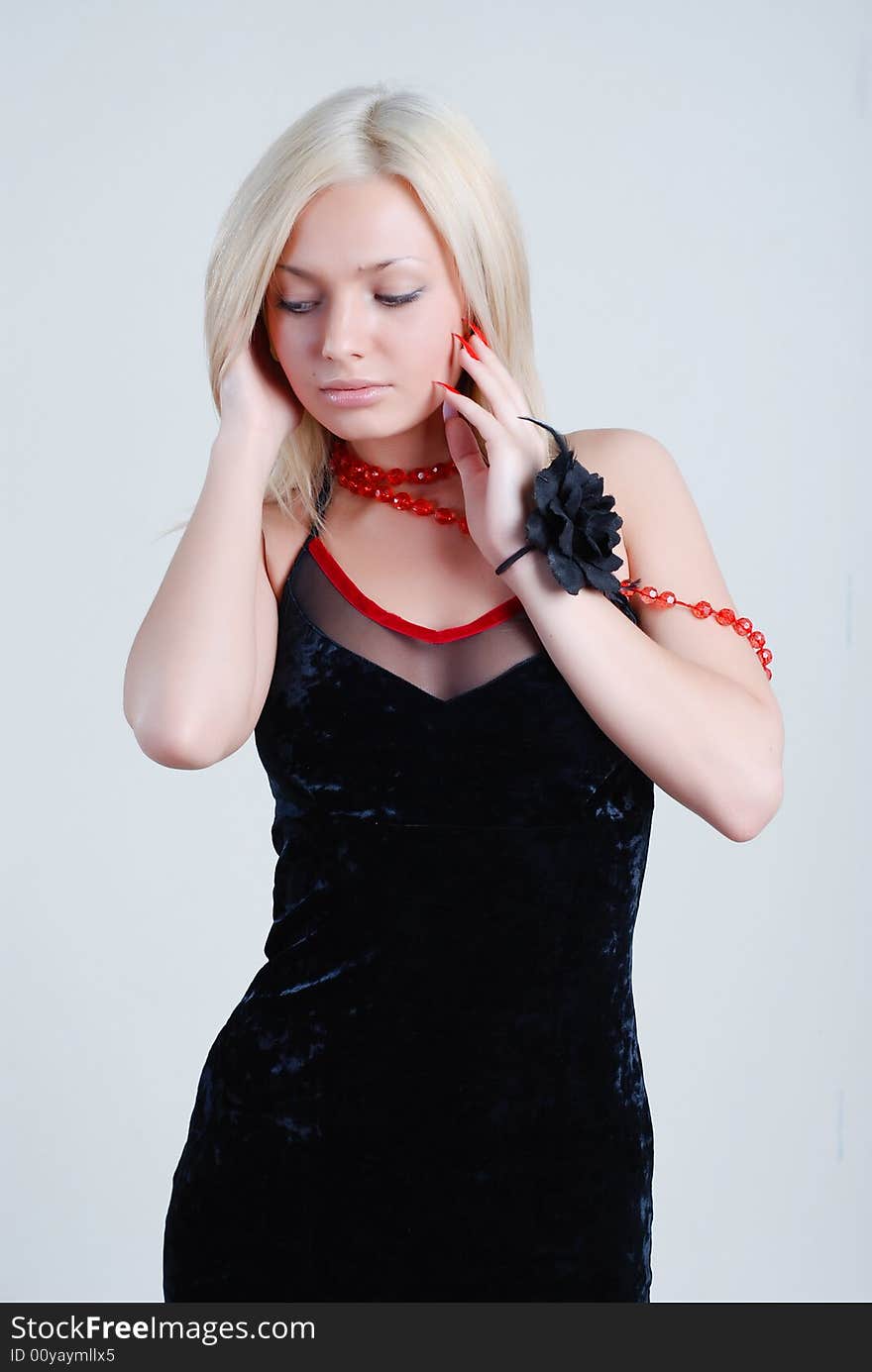 The beautiful blonde with red roses on a neck and a black rose on hand. The beautiful blonde with red roses on a neck and a black rose on hand