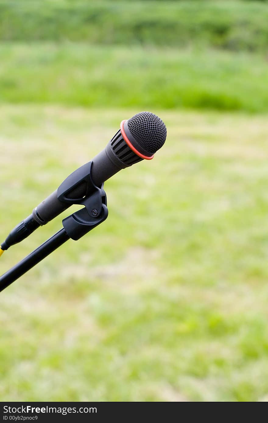 Microphone On Air Over Green Grass Background