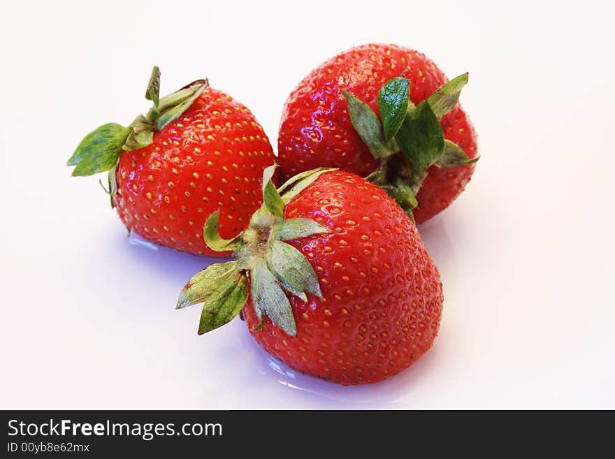 Close-up of three nice fresh strawberry lying in white background