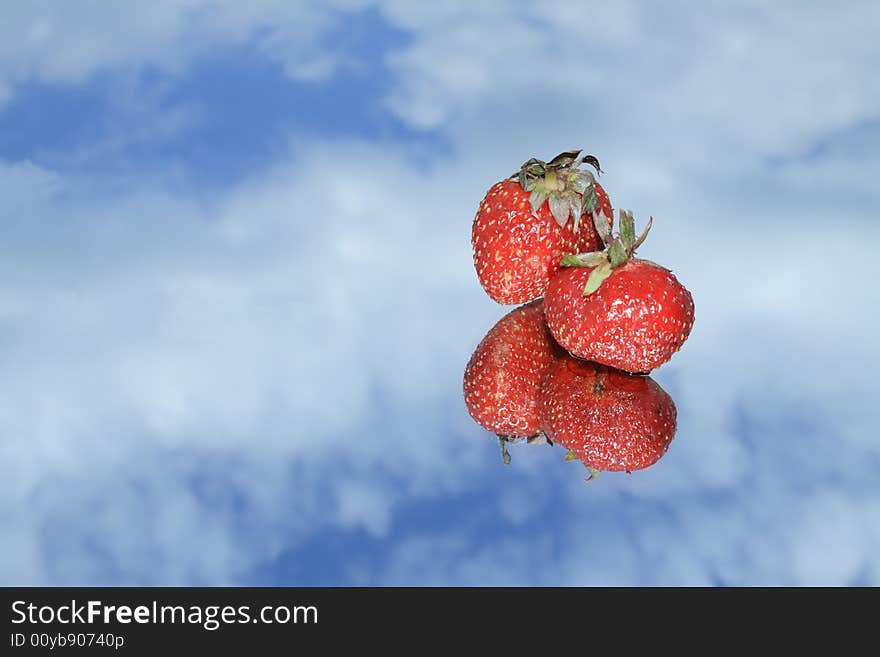 Two nice red strawberry with reverberation lying on blue sky background. Two nice red strawberry with reverberation lying on blue sky background