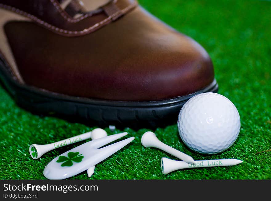 Golf-ball with tees shues on a green ground. Golf-ball with tees shues on a green ground