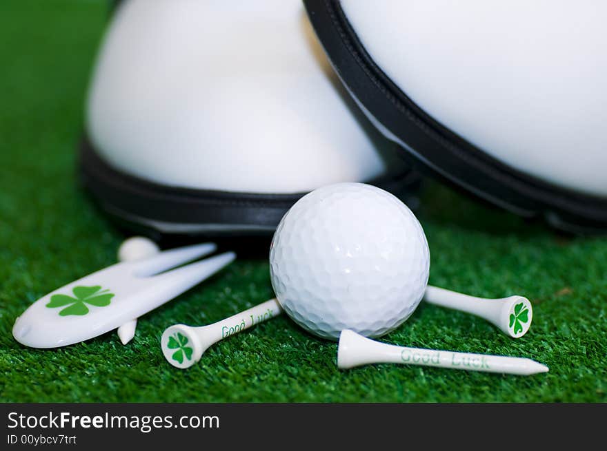 Golf-ball with tees shues on a green ground. Golf-ball with tees shues on a green ground