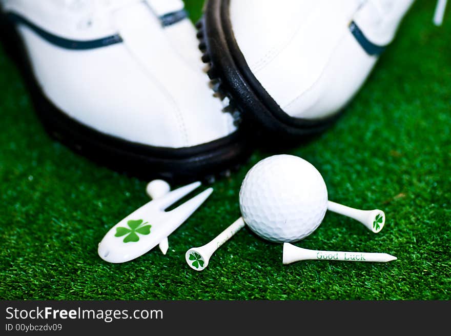 Golf-ball with tees shues on a green ground. Golf-ball with tees shues on a green ground