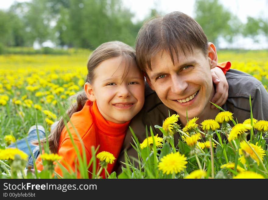 The small daughter and the father in embraces lay on a lawn. The small daughter and the father in embraces lay on a lawn