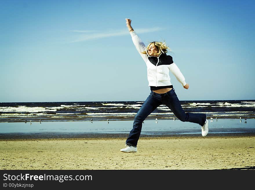 Young girl jumping on the beach. Young girl jumping on the beach.