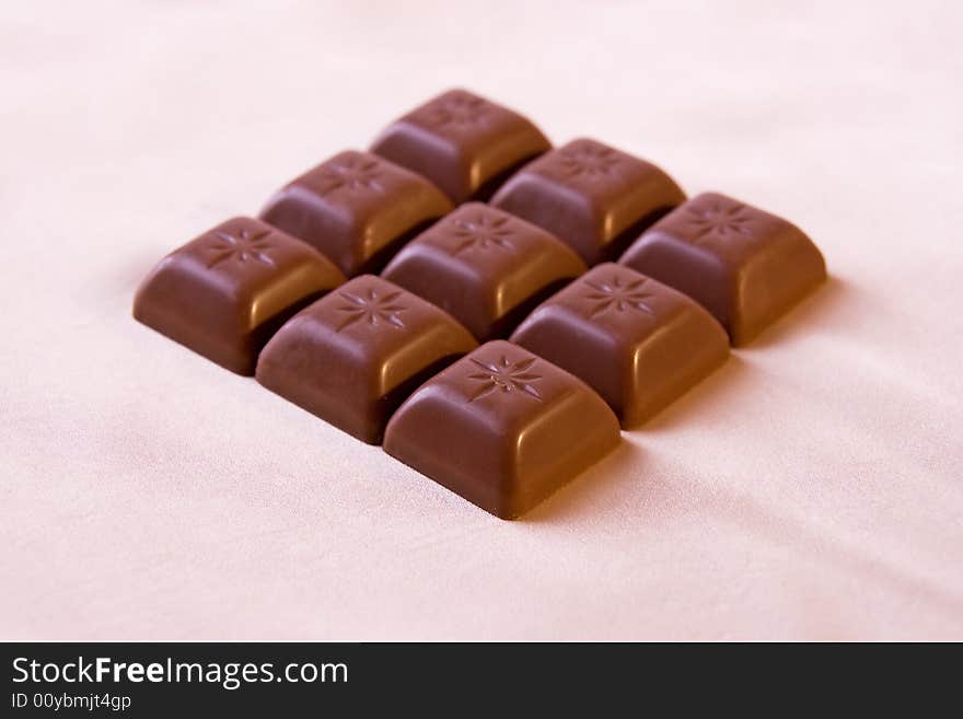 Nine little chocolate bars on beige background. Nine little chocolate bars on beige background