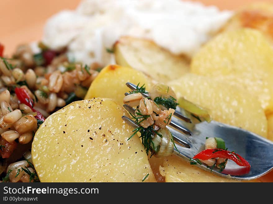 Delicious wheat salad with many ingredients served with oven baked potato. Delicious wheat salad with many ingredients served with oven baked potato