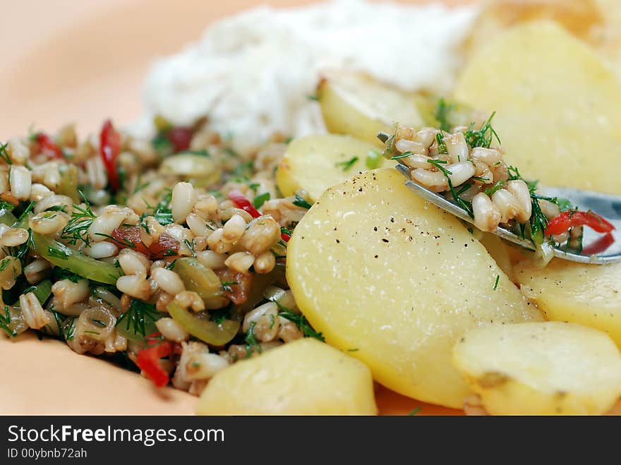 Delicious wheat salad with many ingredients served with oven baked potato. Delicious wheat salad with many ingredients served with oven baked potato