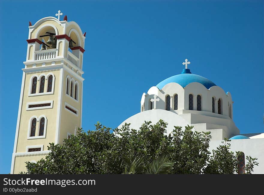 Bell tower and church in hot and sticky Santorini