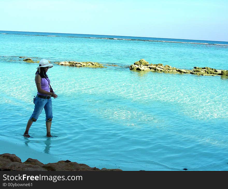 A young model strolling in the sea, lost in her own thoughts