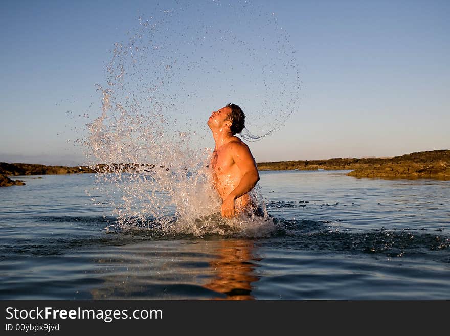 Young athetlic man jumping in the sea water. Young athetlic man jumping in the sea water