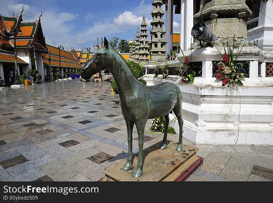 In Thailand, in Bangkok, the wat Suthat Thepwararam is a royal temple from the 19th century; the temple is remarkable for its ancient murals and its collection of Buddha images. view of the courtyard with a horse's statue. In Thailand, in Bangkok, the wat Suthat Thepwararam is a royal temple from the 19th century; the temple is remarkable for its ancient murals and its collection of Buddha images. view of the courtyard with a horse's statue