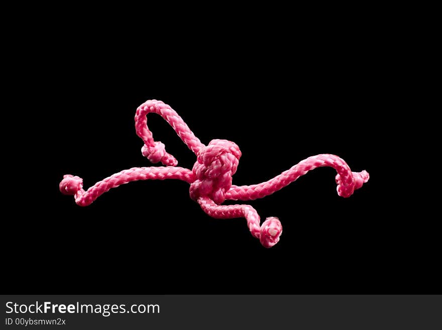 Pink ropes tied together by several Chinese knots, black background. Pink ropes tied together by several Chinese knots, black background