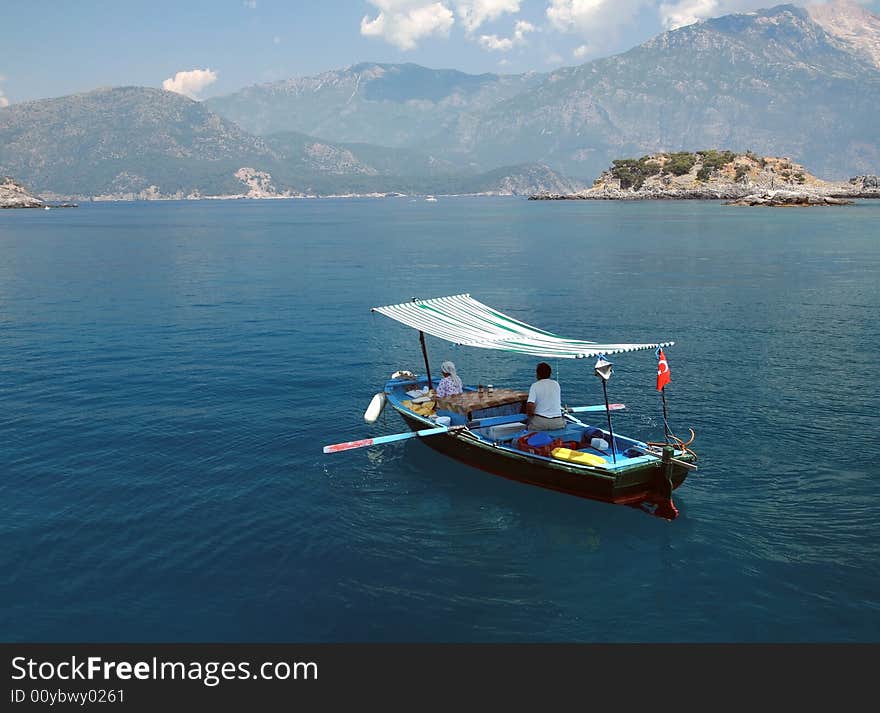 A man and a woman rowing on a small fishing boat