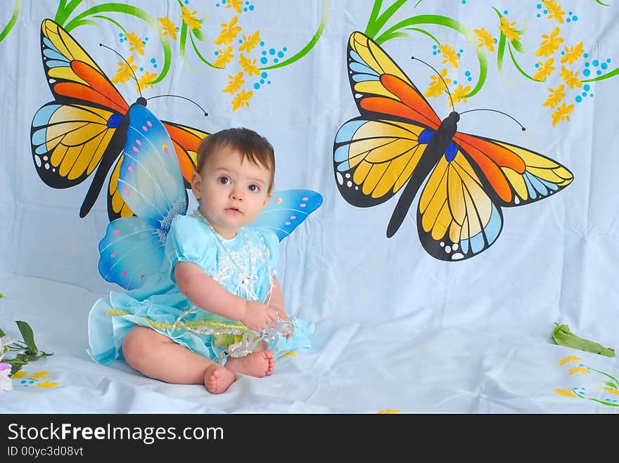 Portrait of a sweet smiling baby girl wearing fancy green dress with butterfly wings. Portrait of a sweet smiling baby girl wearing fancy green dress with butterfly wings