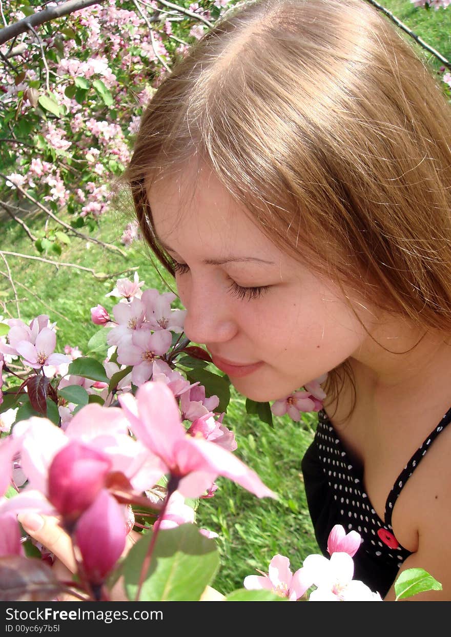 Beautiful young girl at the apple tree. Spring nature.