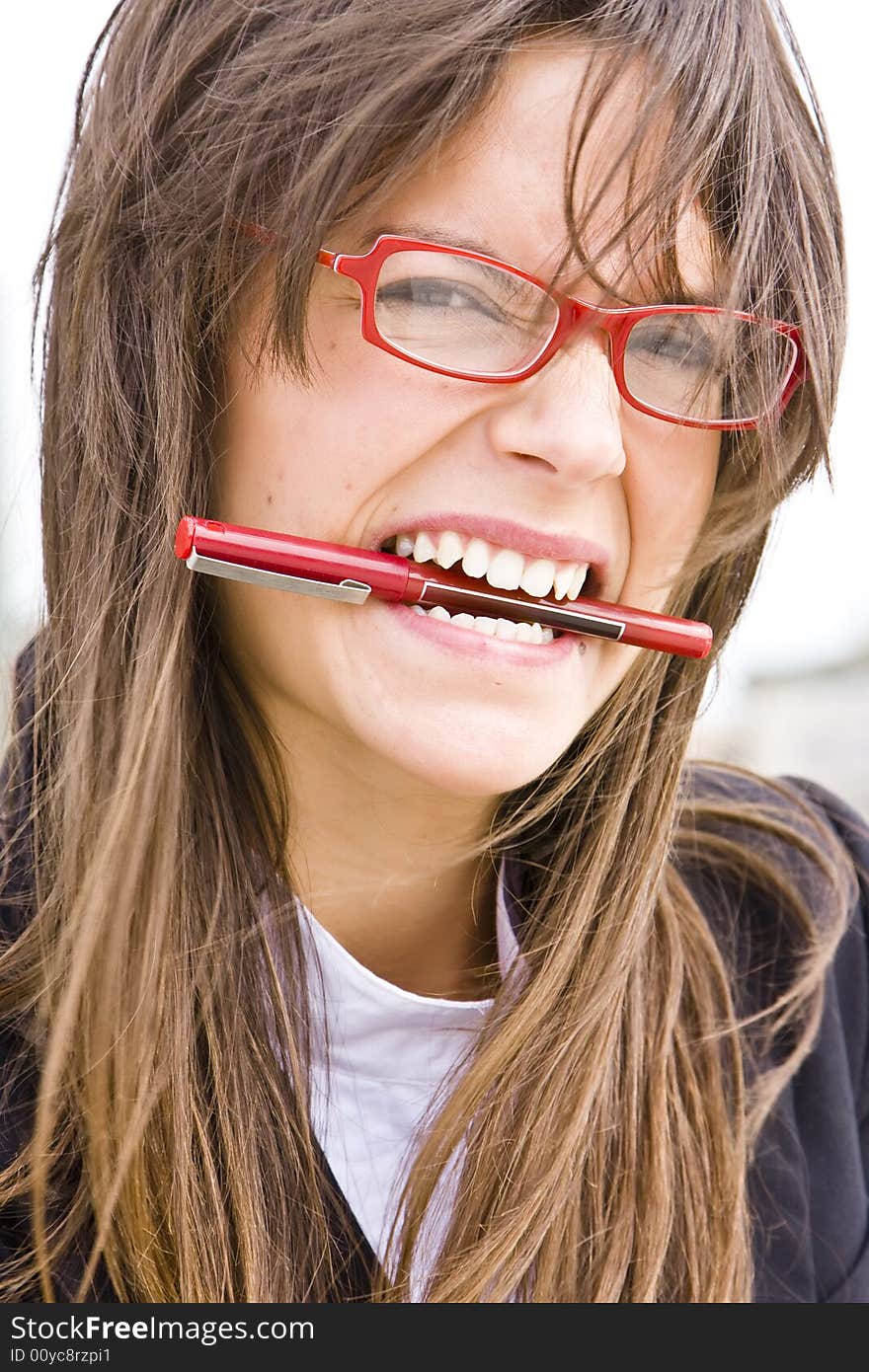 Young businesswoman in red glasses bitin a pen. Young businesswoman in red glasses bitin a pen