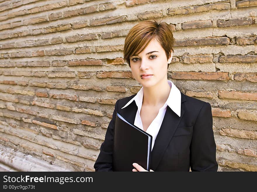 Smiling businesswoman posing on the wall. Smiling businesswoman posing on the wall