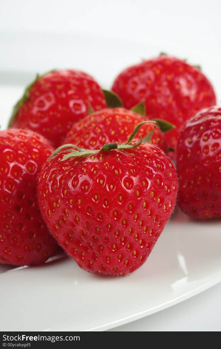 A bunch of strawberries on a plate over white background